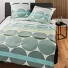 A bed with green and teal patterned bedding, including a duvet cover and pillow. Produktbild-Vorschau