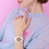 A close-up shot of a woman's wrist wearing a white Casio Baby-G watch, with her hand resting on her light blue sweater. Anteprima dell’immagine prodotto