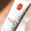 A close-up shot of a white tube of Cell Fusion C Aquaporin Cream, covered in water droplets. Náhled obrázku produktu