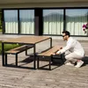 A man is interacting with a modern outdoor dining set on a wooden deck. Náhled obrázku produktu