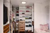A well-organized walk-in closet with shelves, drawers, and hanging clothes. Produktbild-Vorschau