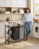 A woman is standing next to a laundry cart in a laundry room. Produktbild-Vorschau