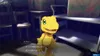 A digital monster character, Agumon, is shown in a dimly lit room with shelves and boxes in the background. Produktbild-Vorschau