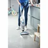 A person is using a cordless vacuum cleaner to clean up a spill on a kitchen floor. Produktbild-Vorschau