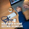 A person is using a laptop on a wooden desk, with a power bank and a cup of coffee nearby. Produktbild-Vorschau