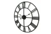 A black metal Roman numeral wall clock is shown against a white background. Anteprima dell’immagine prodotto