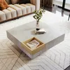 A modern living room setting with a couch and a square coffee table. Produktbild-Vorschau