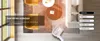A living room scene with a rug, furniture, and a window, featuring a product that appears to be a portable air conditioner or heater. Produktbild-Vorschau