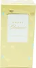 A yellow box with hearts and circles, containing a white label with gold text. Voir les images du produit