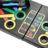A close-up view of a black push-up board with colored markings and text indicating different muscle groups. Produktbild-Vorschau
