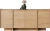 A light wood sideboard with four doors and decorative vases on top, set against a white background. Náhľad obrázku produktu