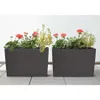 Two dark gray rectangular planters with flowers are shown on a light gray tiled patio. Produktbild-Vorschau