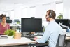 Two people wearing headsets are working at computers in an office environment. Anteprima dell’immagine prodotto