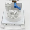 A close-up, angled view of an open white electrical outlet with blue lever, mounted on a white plate. Podgląd zdjęcia produktu