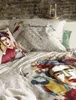 A bed with bedding featuring artwork of Frida Kahlo and parrots. Produktbild-Vorschau