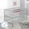 A baby crib with bedding in a room setting. Produktbild-Vorschau