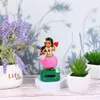 A solar-powered dancing Hawaiian girl figurine is displayed on a white hexagonal stand, surrounded by artificial lavender and succulents in pots. Produktbild-Vorschau