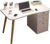 A white corner desk with wooden legs and gray drawers, set up with a laptop, mouse, phone, and desk accessories. Náhľad obrázku produktu