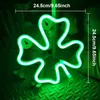 A green neon shamrock light is displayed against a dark, textured background, with measurements indicated. Produktbild-Vorschau