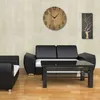 A modern living room with a black sofa, coffee table, and wall art. Voir les images du produit