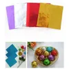 A collage of images showing colorful foil wrappers for candies and chocolates, along with some wrapped chocolates in a heart-shaped box. Produktbild-Vorschau