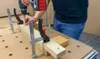 A person is using a drill to screw a piece of wood into another piece of wood, which is held in place by clamps on a workbench. Náhľad obrázku produktu