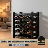 A black wine rack filled with wine bottles in a room with furniture. Produktbild-Vorschau