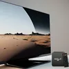 A television displaying a desert landscape, with an Android TV box and remote control in the foreground. Anteprima dell’immagine prodotto
