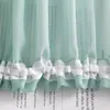 A close-up of a sheer green curtain with white ruffled trim, featuring text printed on the fabric. Produktbild-Vorschau