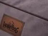 A close-up view of a dog bed with a leather tag. Produktbild-Vorschau