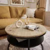 A living room scene with a coffee table in the foreground and a sofa in the background. Produktbild-Vorschau