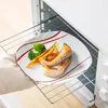 A plate of food being placed into an oven. Produktbild-Vorschau