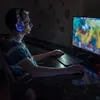 A person wearing a headset and playing a video game on a computer. Voir les images du produit
