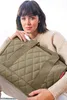 A woman is holding a quilted tote bag. Náhled obrázku produktu