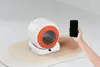 A person is holding a smartphone and pointing it at a self-cleaning cat litter box. Podgląd zdjęcia produktu