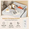 A white bedside table with a built-in charging station, featuring a coffee cup, framed photos, and books. Podgląd zdjęcia produktu
