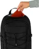 A hand is placing a brown wallet into a black backpack. Voir les images du produit