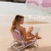 Woman reading on a beach chair under a beach umbrella. Produktbild-Vorschau