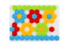 A flat lay of a mosaic toy with hexagonal pieces arranged to form flower shapes on a white background. Produktbild-Vorschau