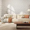 A living room scene with a couch, coffee table, and a textured wall. Voir les images du produit