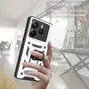 A hand holding a phone case with a ring holder, with a blurred indoor background. Produktbild-Vorschau
