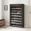 A black fabric shoe rack filled with shoes is placed next to a wooden cabinet. Produktbild-Vorschau