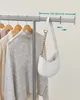 Clothes and a bag on a garment rack. Produktbild-Vorschau