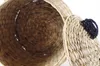 A close-up view of a woven basket with its lid slightly ajar, showing the textured interior and a decorative handle on the lid. Produktbild-Vorschau