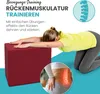 A woman is performing a back exercise using a red cube. Produktbild-Vorschau