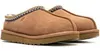 A pair of brown UGG slippers shown from a side angle against a white background. Voir les images du produit
