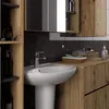 A bathroom sink and vanity area with wooden cabinets and a black marble backsplash. Podgląd zdjęcia produktu