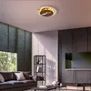 A modern living room with a brown leather sofa, a black metal shelf unit, and a large television. Produktbild-Vorschau