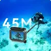 A diver holding a selfie stick with a waterproof case attached, underwater. Produktbild-Vorschau