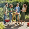 A group of friends enjoying a barbecue in a backyard setting. Produktbild-Vorschau